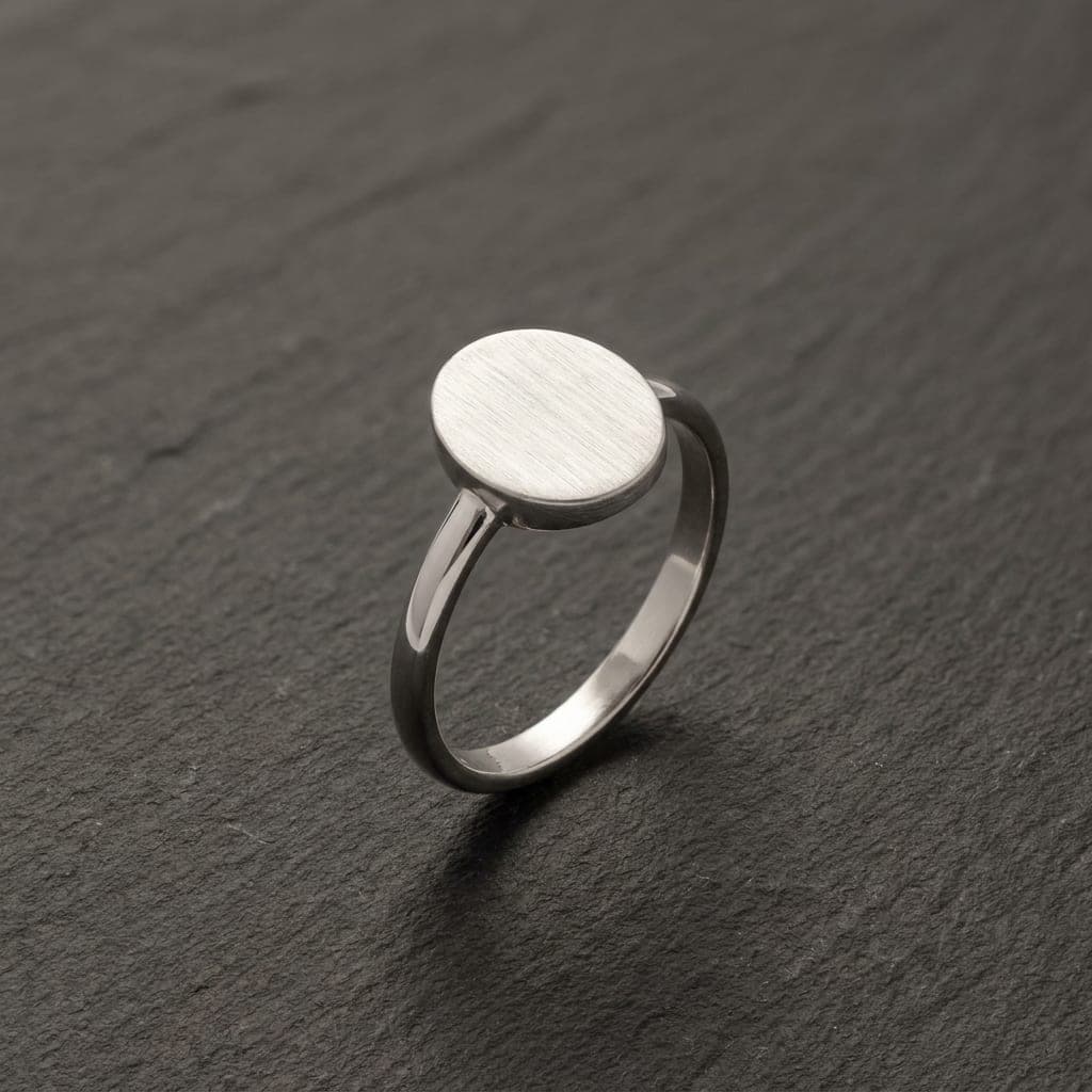Ciutat signet ring in brushed recycled silver, face up on dark slate
