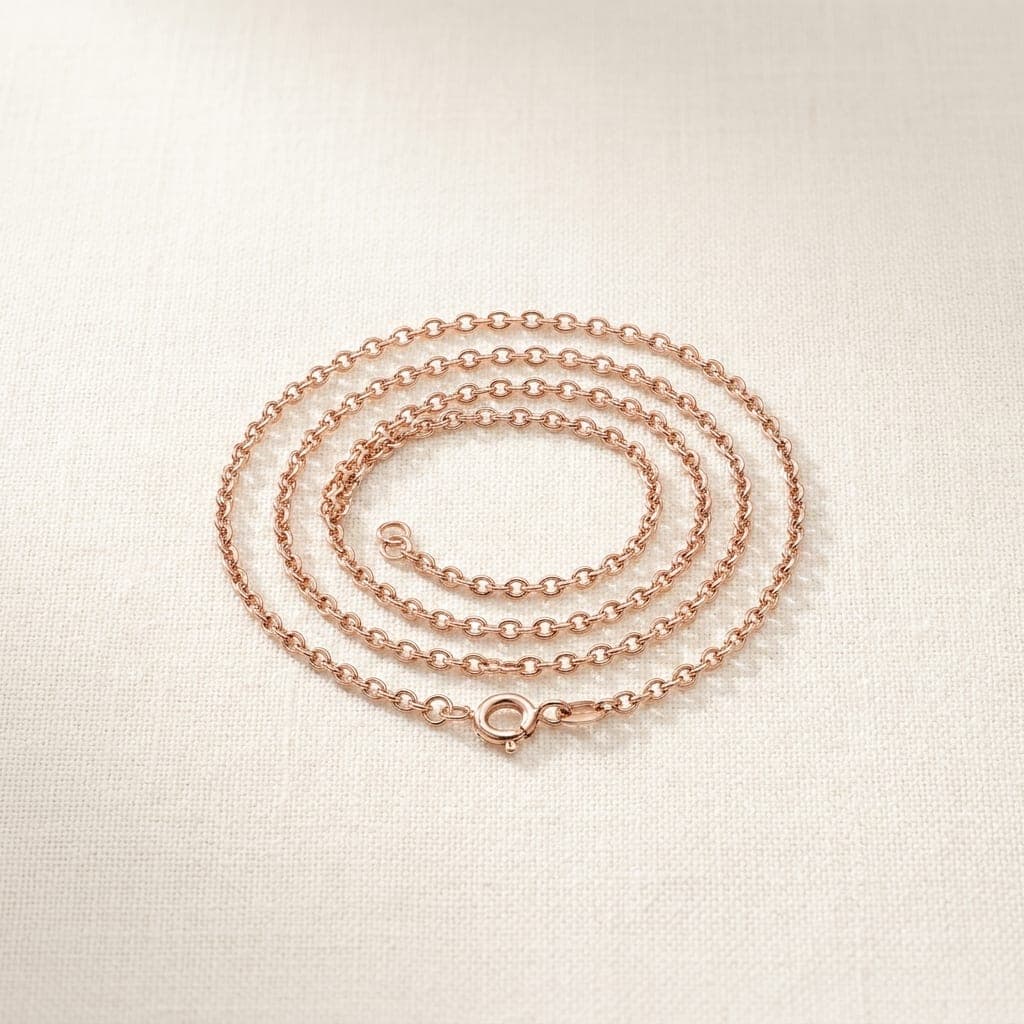 Fil cable chain in rose gold, coiled on ivory linen